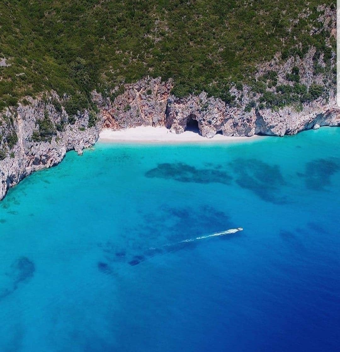 Deep turquoise Albanian sea with boat trail