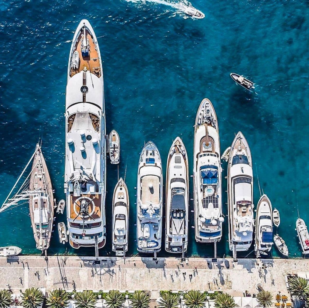 Aerial view of a luxury marina with multiple yachts lined up